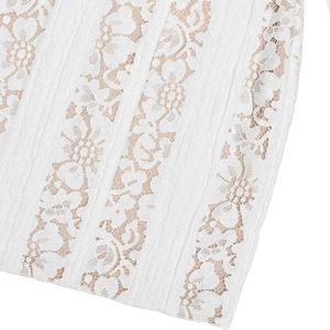 Macro shot of white floral lace fabric with beige lining on a slim-fit long sleeve dress