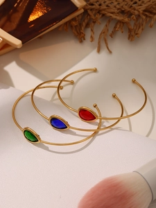 Macro detail of drop-shaped Czech glass open bracelets in 18k gold plated steel
