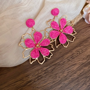 Detailansicht der Bast-Blumenohrringe mit hohlen goldfarbenen Metallblütenblättern