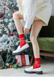 Détail de chaussettes de Noël rouges avec motifs tricotés et flocons dans un décor festif