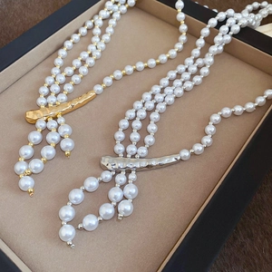 Close-up of triple-layered pearl necklace with hammered metal accents in gold and silver