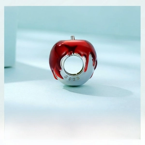 Macro shot of S925 sterling silver apple charm with red enamel and engraved hallmark