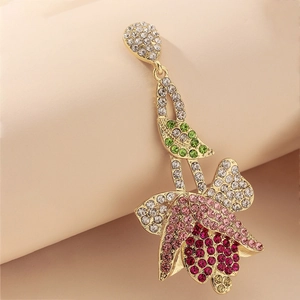 Close-up of golden tulip earrings featuring colorful rhinestones in a floral design