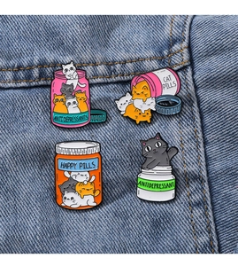 Gros plan détaillé des pin's émaillés chat colorés sur fond de tissu en denim bleu