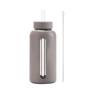 Detail of 800ml glass water bottle with taupe silicone sleeve and long cleaning brush