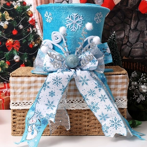 Blue velvet Christmas tree topper hat with snowflake bow on a basket by a cozy fireplace