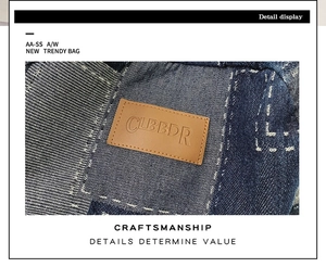 Detail of dark blue denim backpack with a brown leather logo patch and fine stitching