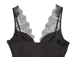 Detail of black satin camisole featuring delicate eyelash lace trim and thin straps