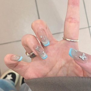 Faux ongles French manucure bleus avec papillon argenté et strass brillants