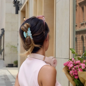 Detailed back view of a blue acetate shark hair claw clip with white bow and pearls
