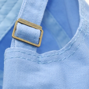 Detail of light blue cotton baseball cap with vintage bronze adjustable metal buckle