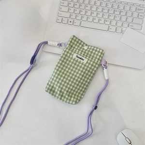 Macro shot of green gingham phone pouch with purple adjustable cord and white button closure