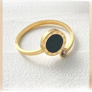 Detail of gold-plated stainless steel ring with black inlay and Roman numeral engravings