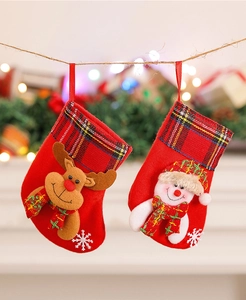 Close-up of small Christmas stockings with 3D reindeer and snowman designs on plaid cuffs