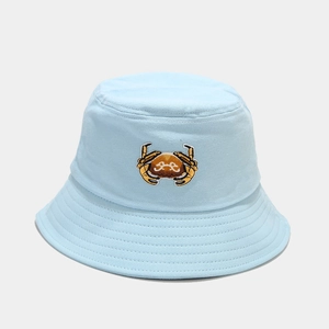 Detail of light blue bucket hat featuring yellow crab embroidery and reinforced stitching