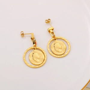 Macro detail of vintage gold coin earrings featuring portrait engraving and polished finish