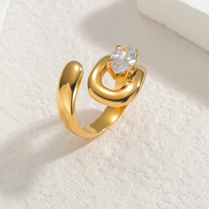 Asymmetrical gold U-shaped open ring with marquise-cut zircon on textured surface