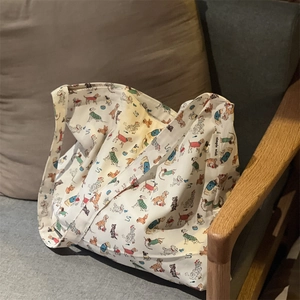 Detailed close-up of cute cartoon dog patterns on a large off-white canvas tote bag