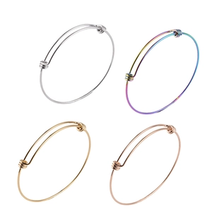 Detail of four-color adjustable 1.6mm stainless steel wire coil bracelets on white