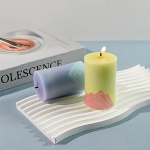 Detail of Alpine mountain relief scent candles in pastel tones on wavy tray
