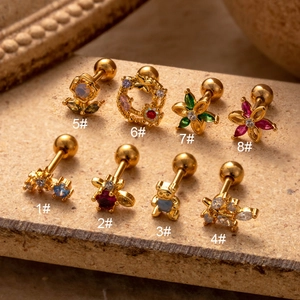 Detailed macro view of gold-plated stainless steel cartilage studs with colorful zircon