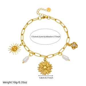 Bracelet doré avec pendentifs tournesol, soleil et perles sur fond blanc immaculé