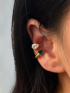 Detail of vintage gold ear cuffs with square emerald and pear-shaped zircon stones