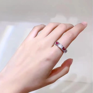 Close-up of adjustable silver ring featuring red heart stones and rectangular zircons