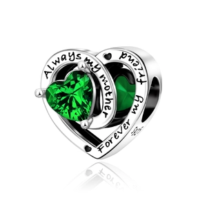 Macro detail of S925 silver heart charm with green zircon and sentimental engraving
