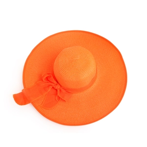 Macro shot of bright orange sun hat showing woven straw texture and large silk ribbon bow