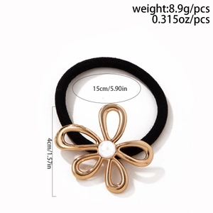 Detail view of black hair tie with golden flower charm, white pearl and size dimensions