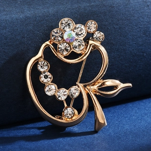 Detailed view of a gold floral brooch with crystals and iridescent gemstones on navy velvet