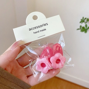 Detail of pink 19mm acrylic flower charms with marble texture for DIY jewelry making