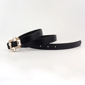 Close-up of a black PU leather belt with a gold square buckle inlaid with rhinestones