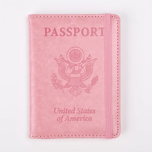 Detalle de funda para pasaporte rosa en cuero con emblema de EE. UU. y banda elástica