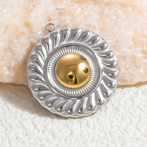 Macro shot of two-tone gold and silver round pendant with radiating texture on stone
