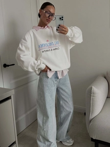 Oversize white letter print sweatshirt with pink shirt and wide leg blue denim jeans