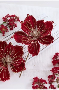Close-up of red velvet artificial poinsettia with gold sequins and beads for Christmas
