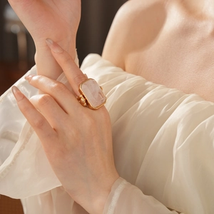 Dettaglio di un grande anello rettangolare con cristallo rosa e fascia dorata chic