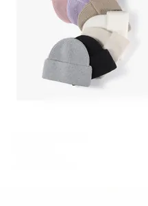 Flat lay of multiple colorful knit beanies showing various autumn and winter color options