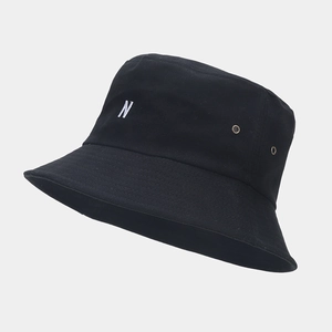 Détail du chapeau bob noir avec broderie 'N' blanche et œillets en laiton