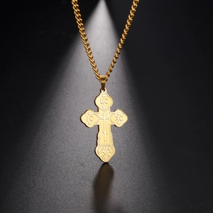 Detail of a golden 304 stainless steel orthodox cross necklace with religious engravings