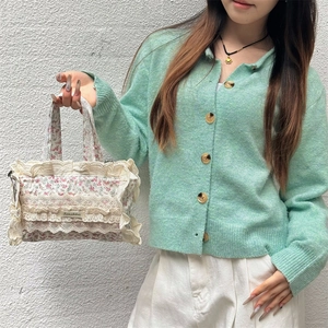 Gros plan détaillé du sac cabas floral avec bordure en dentelle tenu par un modèle