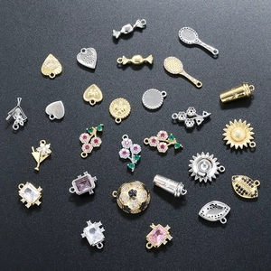 Assorted gold and silver pendants with colorful zircon on a black textured background