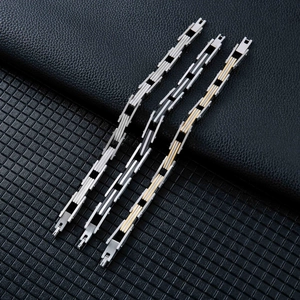 Tre bracciali a catena multistrato in acciaio inossidabile su sfondo in pelle nera
