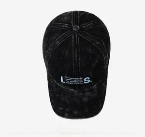 Top-down view of washed black distressed baseball cap with blue I.S. embroidery detail