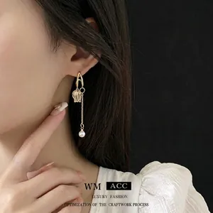 Boucles d'oreilles tulipes dorées élégantes avec cristaux et perle blanche sur modèle