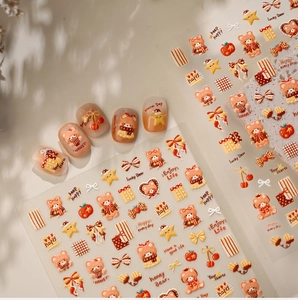 Macro detail of honey caramel bear nail stickers with stars and bows on white background