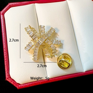 Detail showing 2.7cm starburst gold brooch with cubic zirconia and butterfly clutch back