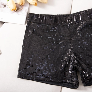 Detail von schwarzen Pailletten-Shorts mit elastischem Bund auf weißem Stoffhintergrund